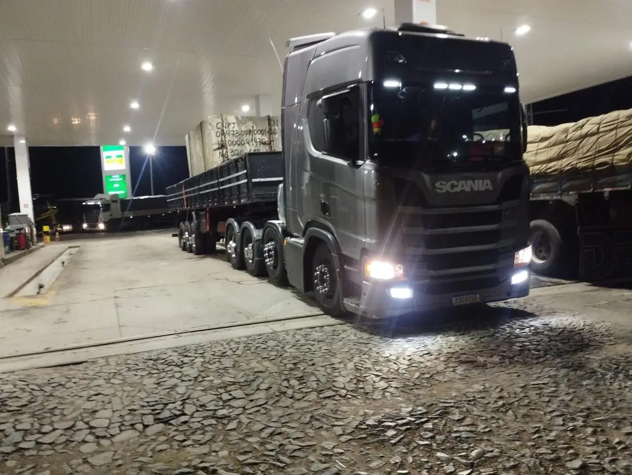 Scania com chapas de rocha parada em posto à noite